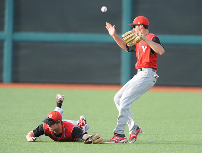 BLOOMINGTON, INDIANA - MAY 30, 2014: Outfielders Jonas Wellan #12 jumps while trying to play the ball and avoid a sliding Kevin Hix #1 of Youngstown State after a bloop Indiana hit during Friday nights regional tournament game against Indiana University. (Photo by David Dermer/Youngstown Vindicator)