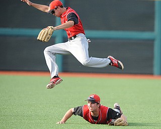 BLOOMINGTON, INDIANA - MAY 30, 2014: Outfielders Jonas Wellan #12 jumps while trying to play the ball and avoid a sliding Kevin Hix #1 of Youngstown State after a bloop Indiana hit during Friday nights regional tournament game against Indiana University. (Photo by David Dermer/Youngstown Vindicator)