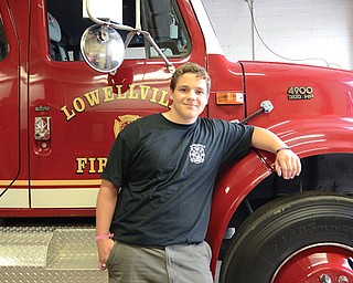 Christopher Inskeep, 17, stands beside a firetruck at the Lowellville Fire Department’s Station 31 on McGaffney Street. The Lowellville High School senior hopes to become one of the first participants in the department’s new cadet program.