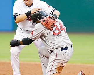 Indians shortstop Asdrubal Cabrera holds onto Red Sox baserunner David Ortiz after Ortiz was out at second
base on a double play in the third inning of Monday’s game at Progressive Field in Cleveland. A.J. Pierzynski
was out at first base.