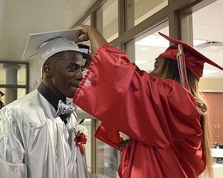 Katie Rickman | The Vindicator.Ta'Kora Nall (on right) fixes the hat of James Gordon prior to commencement at Chaney High School June 6, 2014.