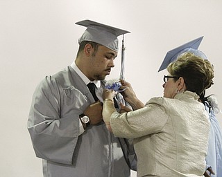 ROBERT K. YOSAY | THE VINDICATOR..Thomas Gallo has his boutineer straightened out by teacher Margaret Stanko before graduation.. . East High School graduation Friday morning at Stambaugh Auditorium