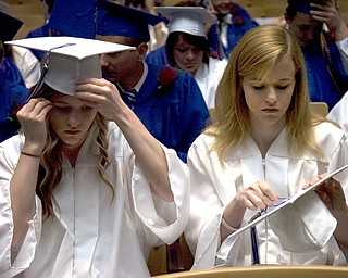 Kelli Cardinal/The Vindicator.Graduate Kayle Augustine, right, fixes the tassel on her cap Sunday next to her twin sister Jessica before walking into the fieldhouse for commencement at Poland Seminary High School.