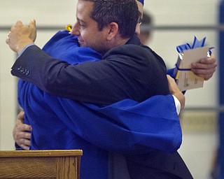 Kelli Cardinal/The Vindicator.Commencement speaker Michael Masucci hugs graduate and class president Alex Ankerman after Ankerman presented him with a gift Sunday from the senior class during the ceremony at Poland Seminary High School.