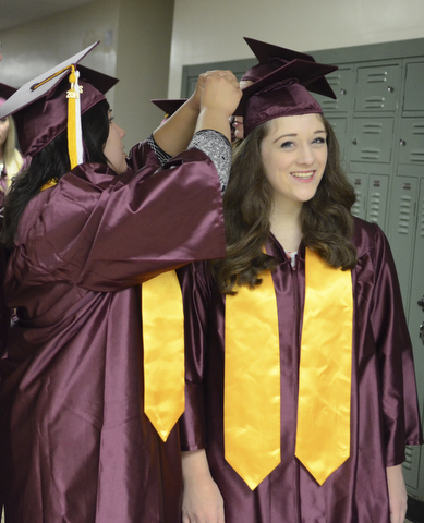 Katie Rickman | The Vindicator.Kristyn Wolf, on left, fixes the graduation cap of  Jenna DeLaurentis prior to the commencement ceremony at Boardman High School June 8, 2014.