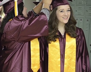 Katie Rickman | The Vindicator.Kristyn Wolf, on left, fixes the graduation cap of Jenna DeLaurentis prior to the commencement ceremony at Boardman High School June 8, 2014.