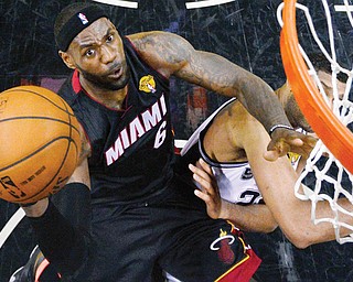Heat forward LeBron James shoots over Spurs forward Tim Duncan during Sunday’s NBA Finals game in San Antonio. James scored 35 points as Miami won to even the series.