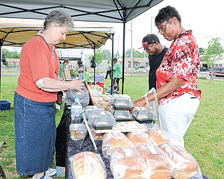 Yvonne Howell and Jarell Houston, at right, both of Youngstown, check out the baked goods for sale by Shelli DelSignore from Shelli’s Cookies at the Idora Neighborhood Farmers Market on Tuesday afternoon. The market at 2600 Glenwood Ave., on the city’s South Side, will be open from 4:30 to 7:30 p.m. every Tuesday through Sept. 30.