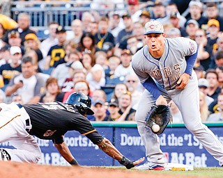 Chicago first baseman Anthony Rizzo, right, takes a throw from starting pitcher Travis Wood as Pittsburgh rookie Gregory Polanco dives back safely to first during the third inning Tuesday night. The Cubs beat the Pirates, 7-3.