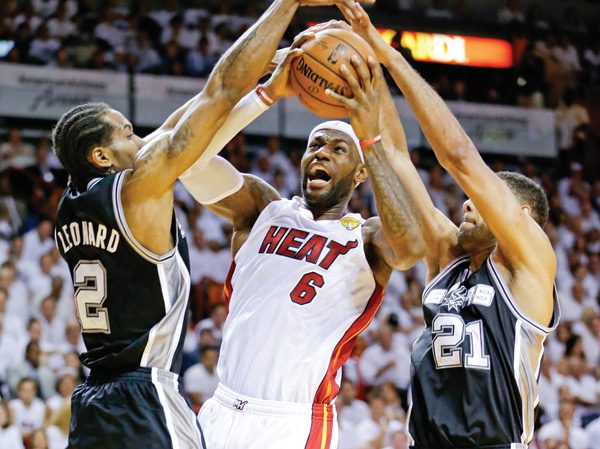 San Antonio Spurs forward Tim Duncan (21) and forward Kawhi Leonard (2) defend Miami Heat forward LeBron James (6) during the first half of Game 3 of the NBA Finals on Tuesday night.