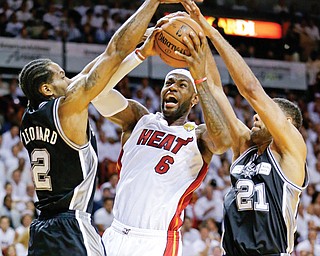 San Antonio Spurs forward Tim Duncan (21) and forward Kawhi Leonard (2) defend Miami Heat forward LeBron James (6) during the first half of Game 3 of the NBA Finals on Tuesday night.