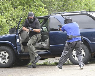 William D Lewis the vindicator Hubbard PD sgt Chris Moffitt, left, portray a bad guy in a training exercise with Hubbard PD ptl Marcus Coonce 6-12 at a vacant building in Hubbard.