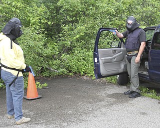 William D Lewis the vindicator Hubbard PD sgt Chris Moffitt , right, portraying bad guy, and Vindy reporter Jeane Starmack during a training exercise 6-12 at a vacant building in Hubbard.