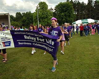 Kelli Cardinal/The Vindicator.Nicole Novotny, center, 23, of Youngstown, leads the survivor lap Friday during the 2014 Austintown Relay For Life event in Austintown Township Park. Novotny was diagnosed with Non Hodgkin's Lymphoma at age 19.