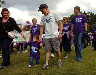 Kelli Cardinal/The Vindicator.Dalton Bodnar, center, 20-months-old, of Youngstown, walks the survivor lap Friday with mom Dana, and dad Michael during the 2014 Austintown Relay For Life event in Austintown Township Park. Dalton Bodnar, who's been in remission for 8 months, was diagnosed with testicular cancer a week after his first birthday.