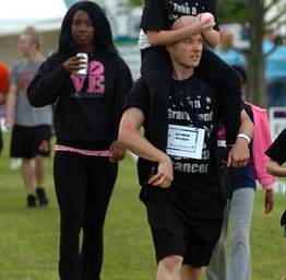 Kelli Cardinal/The Vindicator.Jordan Miller, of Austintown, walks Friday and carries Brooklyn Youngblood, 9, of Girard, on his shoulders during the 2014 Austintown Relay For Life event in Austintown Township Park. Miller is a 24-hour walker with team PsyCare.