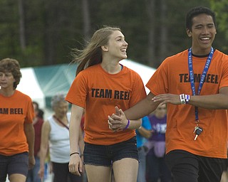 Kelli Cardinal/The Vindicator.Emma Hartshorn, 16, of Canfield, walks Friday with her boyfriend Kato Kim, 16, of Canfield, during the 2014 Austintown Relay For Life event in Austintown Township Park. The couple was walking for former middle school teacher Ken Reel, who lost his battle with cancer.