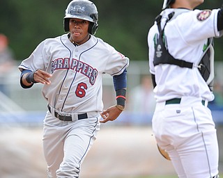 JAMESTOWN, NEW YORK - JUNE 13, 2014: Base runner Joel Mejia #6 of the Scrappers steps on home plate to score the first scrappers run of the game int he top of the 1st inning during a game at Russell Diethrick Park. (Photo by David Dermer/Youngstown Vindicator) Jamestown catcher Taylor Gushue #13 pictured.