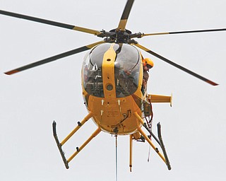 FirstEnergy of Northeast Ohio uses helicopters to build a 345-kilovolt power line running from Beaver County in
Pennsylvania to Cuyahoga County. This process minimizes enviromental damage and proves to be more efficient for the company, FirstEnergy says. The workers in these photos are building the line in southern Mahoning County.