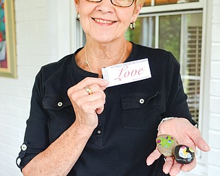 Mary Ann Dieter holds out Love Rocks made at the Paisley House in Youngstown recently. The concept of the rocks came from a personal tragedy that Dieter’s family experienced.