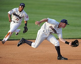 NILES, OHIO - JUNE 17, 2014: Infielder Austin Fisher #12 of the Scrappers charges in to make a play on a ground ball in the top of the 4th inning during Tuesday nights New York Penn League game at Eastwood Field. (Photo by David Dermer/Youngstown Vindicator) Infielder Ordomar Valdez #11 pictured.
