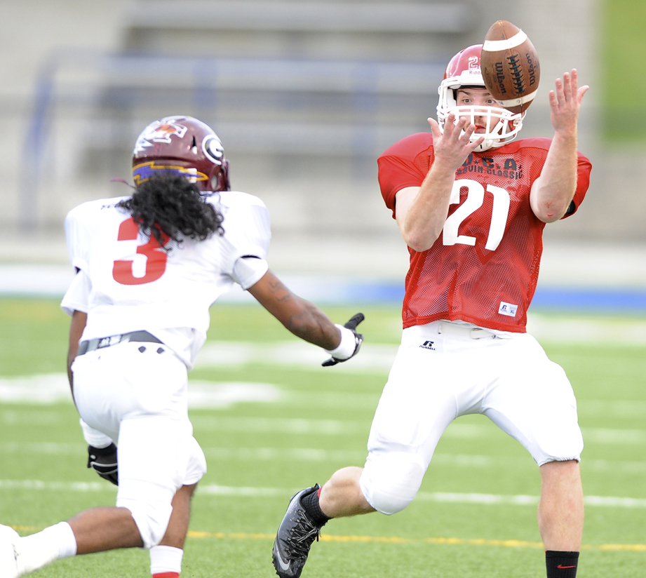 Mahoning County's running back Nick Pollifrone bobbles the ball before being hit by Trumbull County's defensive back Daquan Carter  during the 2nd quarter of the Mahoning Valley Coaches Association's Jack Arvin Football Classic Thursday at Hubbard High School.