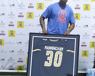 Kate Rickman | The Vindicator.Mario Manningham stands behind his high school jersey during the a short ceremony where Coach Steven Arnold declared #30 a retired number for Warren G. Harding High School football June 21, 2014.
