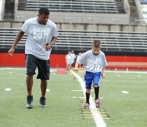 YOUNGSTOWN, OHIO - JUNE 21, 2014: Jordan Valdez works on quick feet in a rope drill with Brad Smith next to him encouraging him during the Brad Smith Football Camp at Stambaugh Stadium on the campus of Youngstown State Saturday morning. (Photo by David Dermer/Youngstown Vindicator)