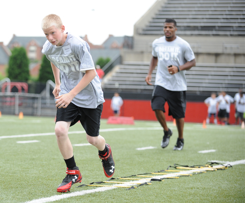 YOUNGSTOWN, OHIO - JUNE 21, 2014: Machael Johnson works on quick feet in a rope drill with Brad Smith next to him encouraging him during the Brad Smith Football Camp at Stambaugh Stadium on the campus of Youngstown State Saturday morning. (Photo by David Dermer/Youngstown Vindicator)
