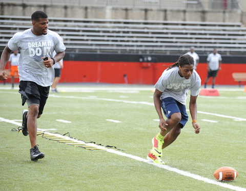 YOUNGSTOWN, OHIO - JUNE 21, 2014: Tristan Ballard prepares to scoop up the football to score with Brad Smith next to him encouraging him during the Brad Smith Football Camp at Stambaugh Stadium on the campus of Youngstown State Saturday morning. (Photo by David Dermer/Youngstown Vindicator)