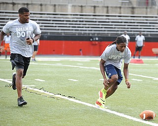 YOUNGSTOWN, OHIO - JUNE 21, 2014: Tristan Ballard prepares to scoop up the football to score with Brad Smith next to him encouraging him during the Brad Smith Football Camp at Stambaugh Stadium on the campus of Youngstown State Saturday morning. (Photo by David Dermer/Youngstown Vindicator)