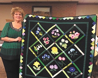 SPECIAL TO THE VINDICATOR
Barbara King, assistant warden at Lorain Correctional Institution, displays a quilt made by a male inmate at the Grafton facility. A select group of inmates are chosen for the quilting program, and all quilts are donated to charities. King recently spoke to members of That Quilt Group I Belong To of Canfield and showed a variety of quilts made by the inmates. All of the fabric and supplies for the program are donated by quilt groups, quilt stores and individuals. No state funds are used.