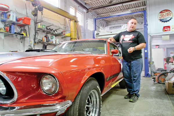 Nate Miller stands near a 1969 Mustang Mach 1 that his Canfield company is restoring. Miller owns Buckeye Classic Car Restoration. He’s also branching out into reproducing Mustang Fastbacks through a sister company called Thoroughbred International.