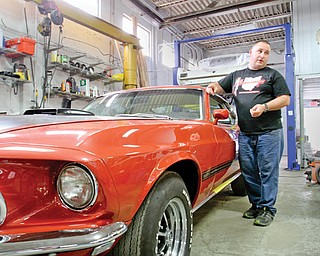 Nate Miller stands near a 1969 Mustang Mach 1 that his Canfield company is restoring. Miller owns Buckeye Classic Car Restoration. He’s also branching out into reproducing Mustang Fastbacks through a sister company called Thoroughbred International.