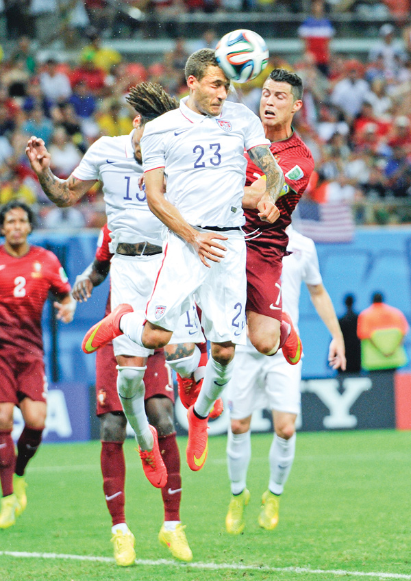 The United States’ Fabian Johnson (23) heads the ball away from Portugal’s Cristiano Ronaldo, right, during the
group G World Cup soccer match between the USA and Portugal at the Arena da Amazonia in Manaus, Brazil, on
Sunday.