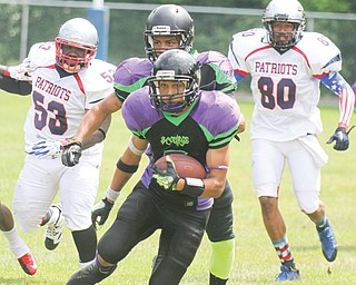 Scourge ballcarrier Brandon Rutland (5) looks for running room while being pursued by Cleveland Patriots KayRon Purdie (53 and Weadell Chery (80) during Sunday’s game in Poland. Behind Rutland is Scourge teammate Jaymes Williams (8).