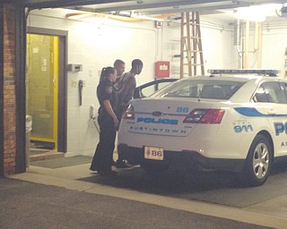 Ricki D. Williams IV, 18, of Youngstown is escorted into a cruiser by Austintown police after he was picked up by U.S. marshals and arrested Tuesday on murder and kidnapping charges. Williams is due in Mahoning Area Court
today for arraignment.