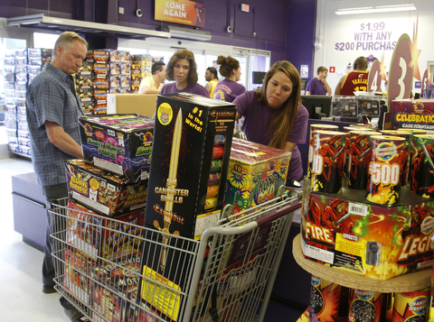  Gaven Hedrick of Erie, Pa., heads to the checkout at Phantom Fireworks in Youngstown with Annika Bunevich as Jessica Markowitz runs the scanner.  Phantom Fireworks is again the #1 shop to buy fireworks as the Valley gets ready for the big booming holiday.