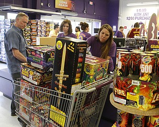  Gaven Hedrick of Erie, Pa., heads to the checkout at Phantom Fireworks in Youngstown with Annika Bunevich as Jessica Markowitz runs the scanner.  Phantom Fireworks is again the #1 shop to buy fireworks as the Valley gets ready for the big booming holiday.