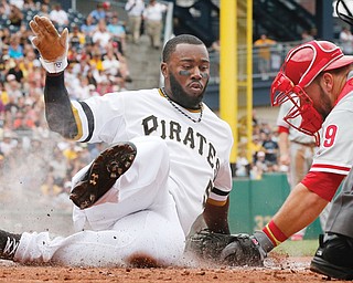 The Pirates’ Josh Harrison scores ahead of the tag by Phillies catcher Cameron Rupp during the third inning of Sunday’s game in Pittsburgh. The Pirates won 6-2 and earned their first series sweep this season.