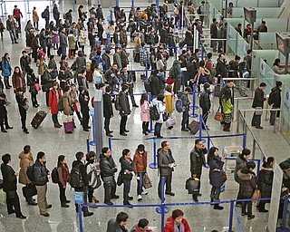 Passengers line up for a security check at Pudong International Airport in Shanghai, China. The Transportation Security Administration is requiring passengers at some overseas airports that offer U.S.-bound flights to power on their electronic devices, the agency said Sunday. American intelligence officials have been concerned about new al-Qaida efforts to produce a bomb that would go undetected through airport security.