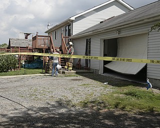        ROBERT K. YOSAY  | THE VINDICATOR..The garage door was buckled by the wind as .A house had its roofing blown off and a side wall blown out by the storm on 9000 block of Canfield Akron Rd (224) .a small structure of the neighbors used for students waiting on a bus was destroyed ...  -30-