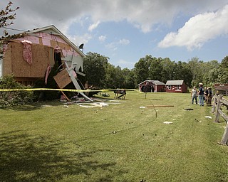        ROBERT K. YOSAY  | THE VINDICATOR...A house had its roofing blown off and a side wall blown out by the storm on 9000 block of Canfield Akron Rd (224) .a small structure of the neighbors used for students waiting on a bus was destroyed ...  -30-