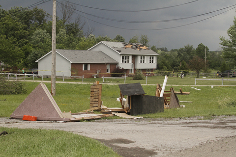        ROBERT K. YOSAY  | THE VINDICATOR...A house had its roofing blown off and a side wall blown out by the storm on 9000 block of Canfield Akron Rd (224) .a small structure of the neighbors used for students waiting on a bus was destroyed ...  -30-