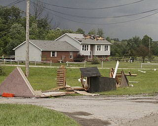        ROBERT K. YOSAY  | THE VINDICATOR...A house had its roofing blown off and a side wall blown out by the storm on 9000 block of Canfield Akron Rd (224) .a small structure of the neighbors used for students waiting on a bus was destroyed ...  -30-