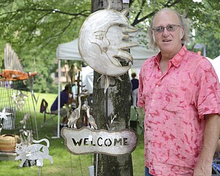 Katie Rickman | The Vindicator.Alex Stoll of Collins, Ohio, stands beside some of his stainless steel yard art at the Summer Festival of the Arts Saturday. Stoll has been selling his handcrafted items at the event, which takes place on the campus of Youngstown State University, for the past 13 years.