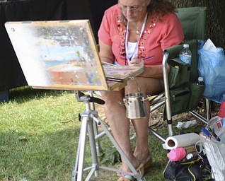 Katie Rickman | The Vindicator.Catherine Kendrick of Salineville paints beside her tent. Kendrick has been selling her wares at the festival, located on the campus of Youngstown State University, for the past four years.