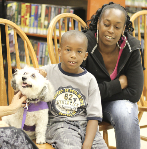 Braylen Miller (middle) and his mother Monica Brown of Youngstown pet "Meja", a 10 year old Schnoodle at the Brownlee Woods branch of the Public Library of Youngstown on Saturday afternoon.   Dustin Livesay  |   The Vindicator 7/19/14  Youngstown.