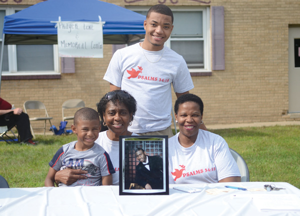 Georgia West, second from left, founder of Survivors of Our Grief, holds her 5-year-old grandson, Isaiah O’Neal, at the “Knock Out the Violence” event in Boardman. One of her sons, Ivan West, murdered last year in Youngstown, is in the picture. Also with her was another son, Sheldon Grayson, and Addie Smith, a Survivors member.