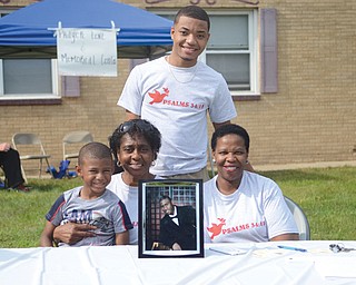 Georgia West, second from left, founder of Survivors of Our Grief, holds her 5-year-old grandson, Isaiah O’Neal, at the “Knock Out the Violence” event in Boardman. One of her sons, Ivan West, murdered last year in Youngstown, is in the picture. Also with her was another son, Sheldon Grayson, and Addie Smith, a Survivors member.